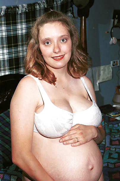 Brunetta incinta in posa sul suo letto
 #16446503