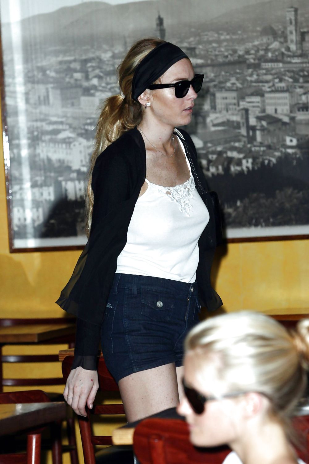 Lindsay Lohan is leggy smoking a cigarette in denim shorts