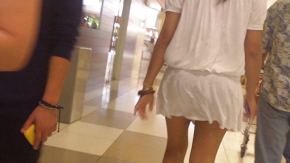 白いミニスカートと赤い靴を履いたかわいい女の子のお尻とお尻
 #12647502
