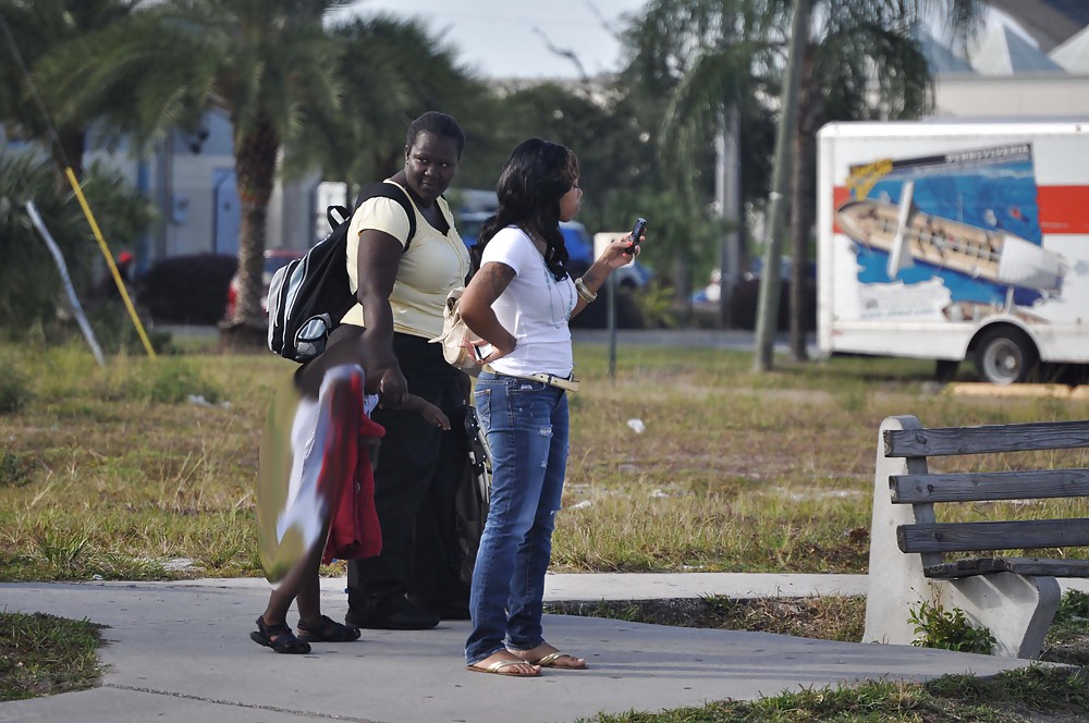 痩せた黒人女性がバス停でぽっちゃりした黒人女性と一緒にいるところ
 #11276088