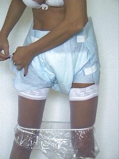 ブロンドの女性がプラスチックのパンツとオムツを履く
 #2706592