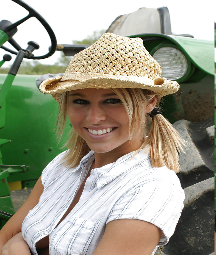 Blond girl infront of a old john deere tractor #4619268