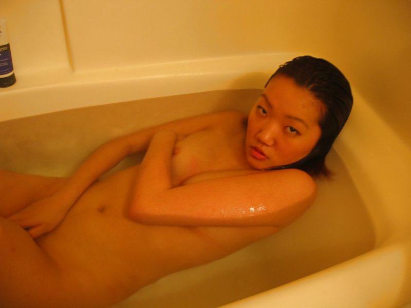 Asian woman with limited breasts bare in bathtub