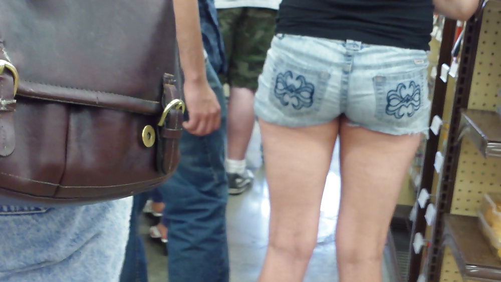 De pie en la línea detrás de la señorita de azúcar culo y el culo en pantalones cortos
 #11808505