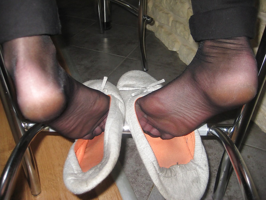 Les Pieds De Femme Parfumée Dans Des Collants Noirs Et Des Chaussons #21884368