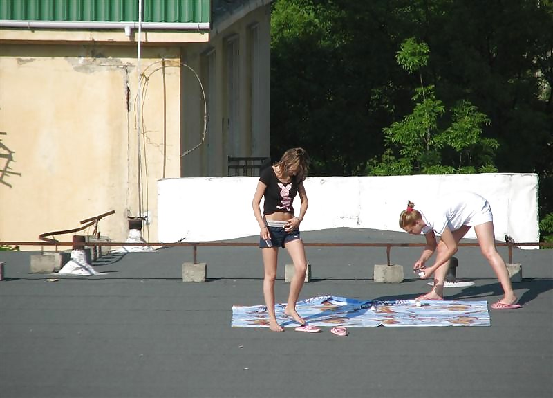 Three vouyered girls undressing and sunbathing in the roof.