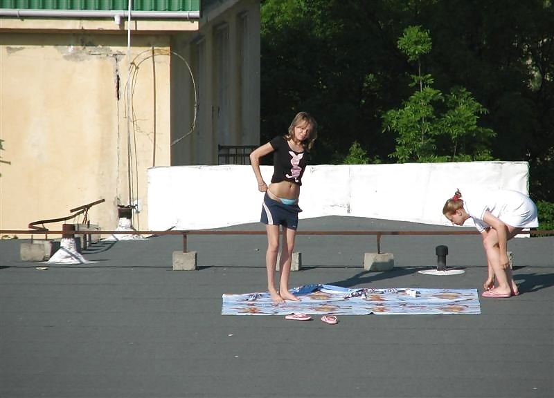 Tre ragazze vouyered che si spogliano e prendono il sole sul tetto.
 #37224177