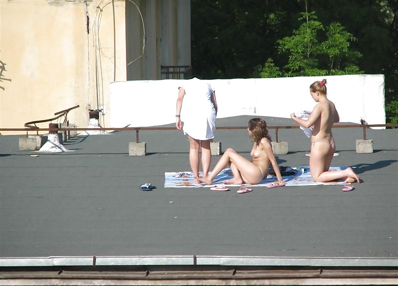 Tre ragazze vouyered che si spogliano e prendono il sole sul tetto.
 #37224190