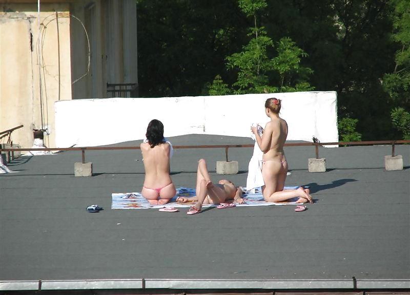 Three vouyered girls undressing and sunbathing in the roof. #37224193