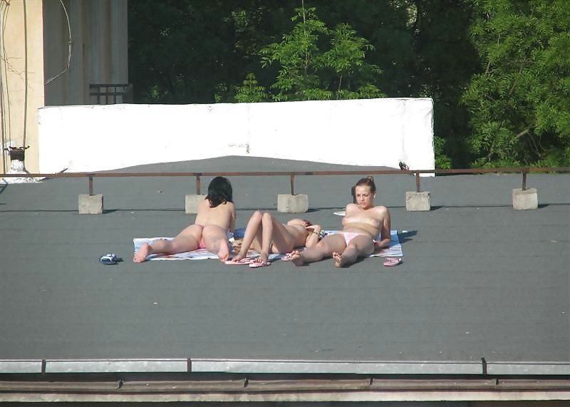 Three vouyered girls undressing and sunbathing in the roof. #37224196