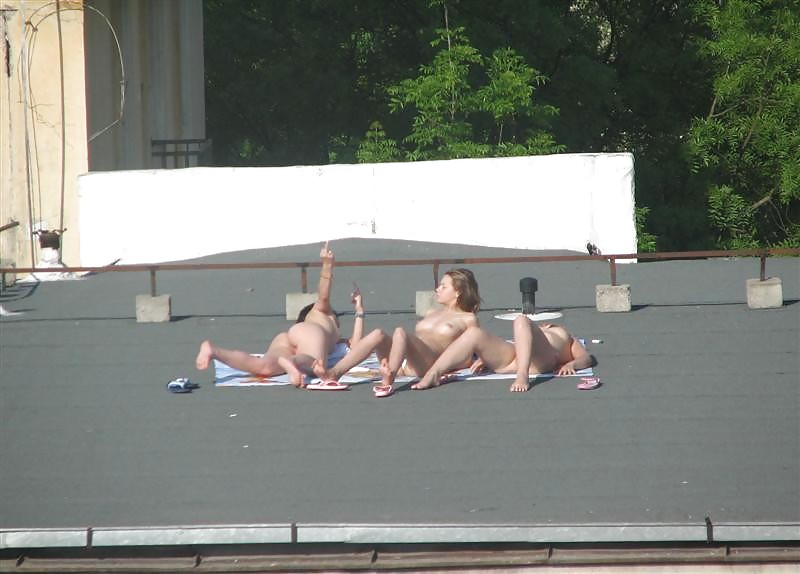 Three vouyered girls undressing and sunbathing in the roof. #37224199