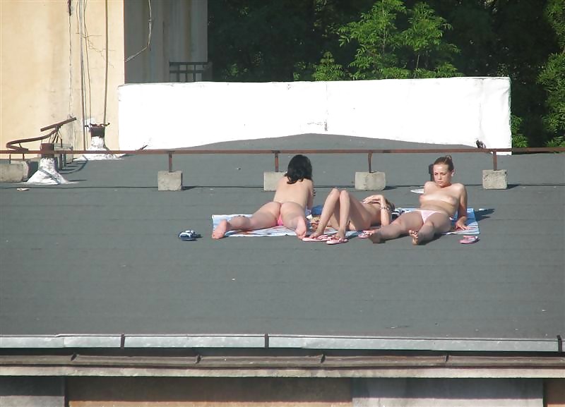 Three vouyered girls undressing and sunbathing in the roof. #37224201