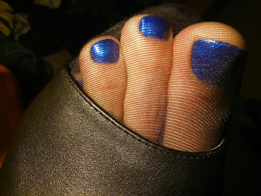 Pies en medias negras, tacones de cuero y esmalte azul
 #33374542