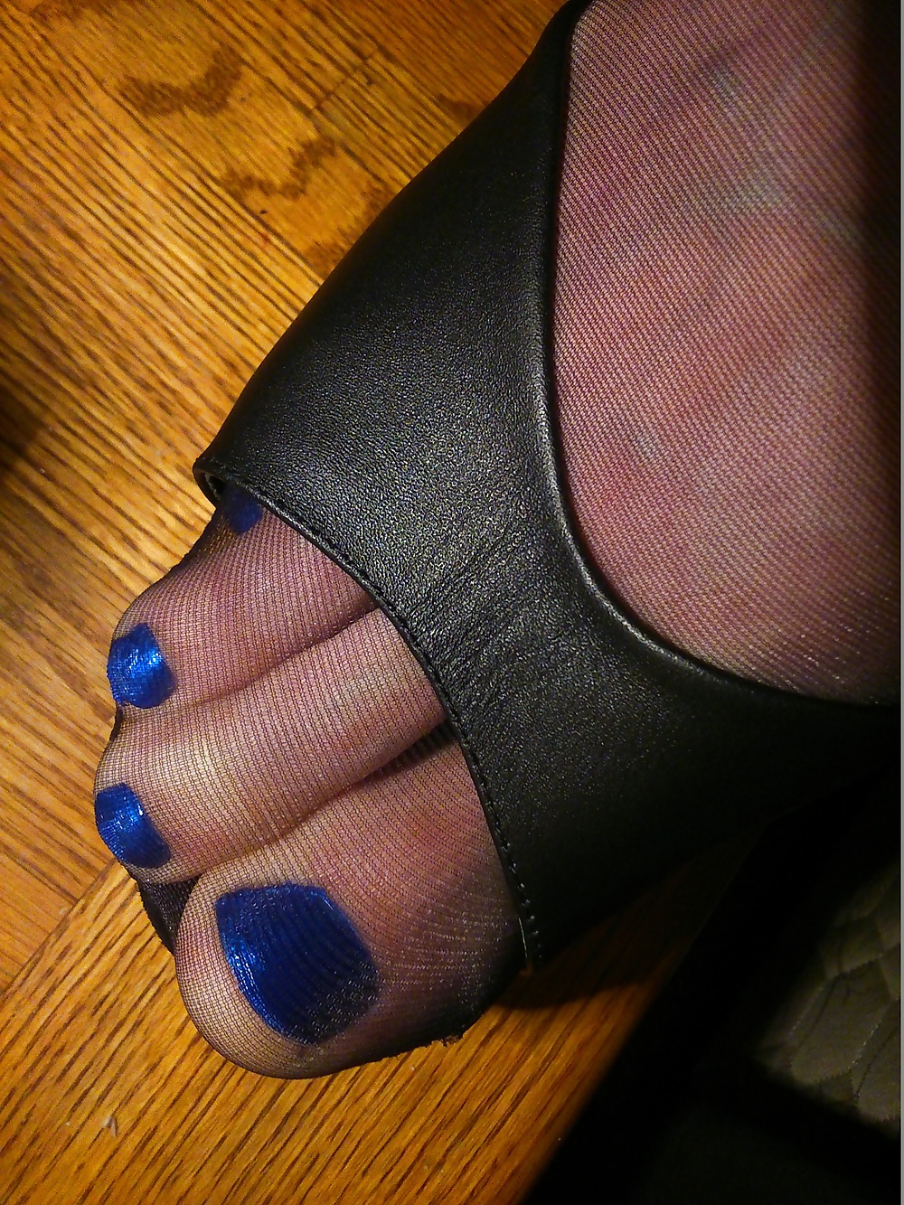 Feet In Black Stockings, Leather High Heels And Blue Polish #33374551