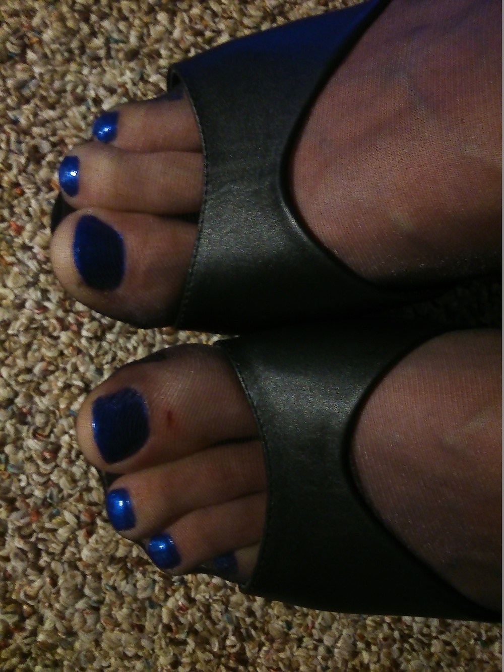Pies en medias negras, tacones de cuero y esmalte azul
 #33374564