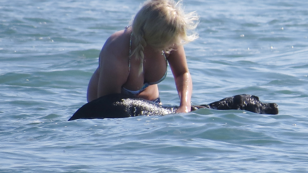 Rubia tetona y su perro, jugando en las olas.
 #39778126