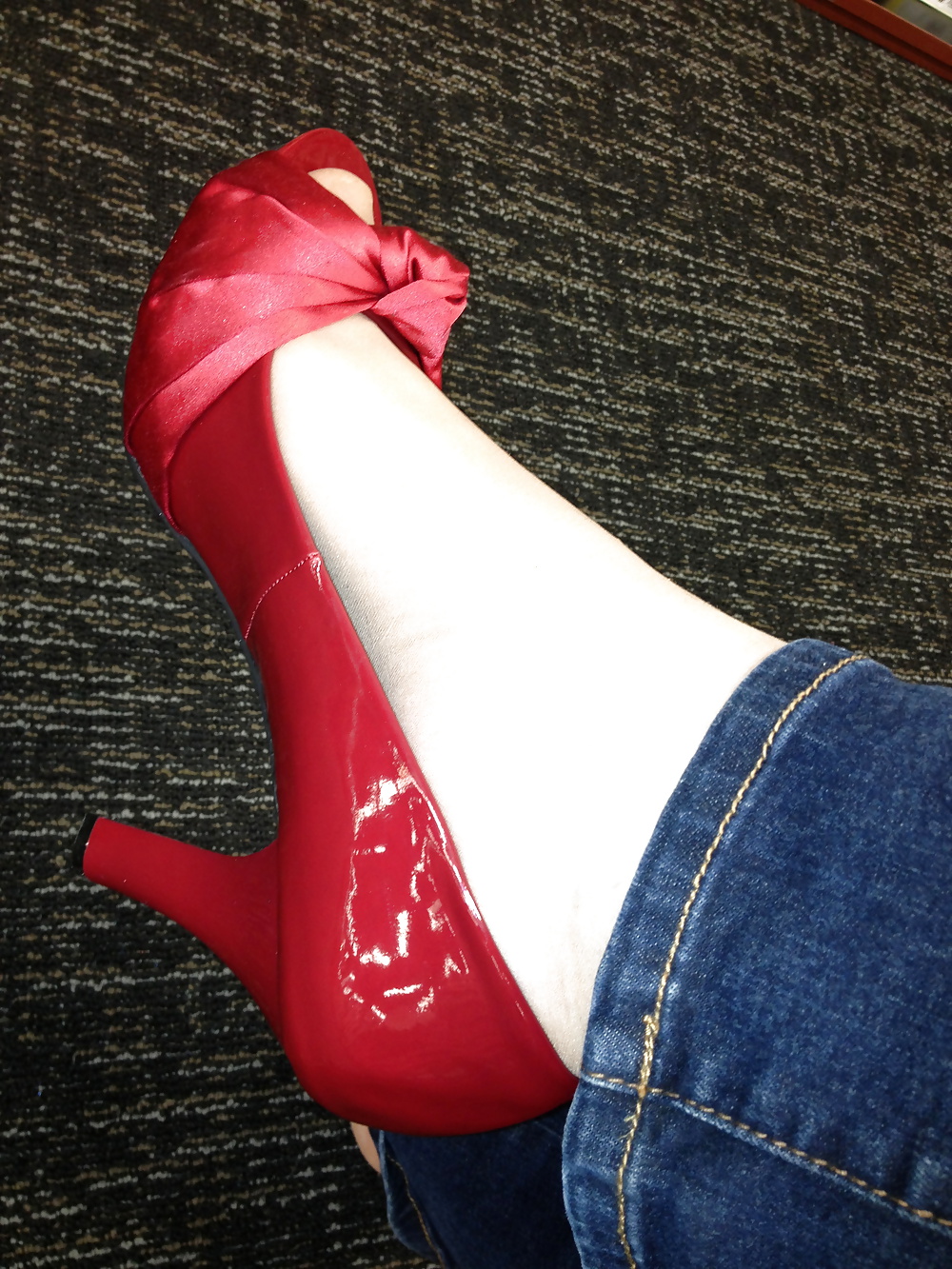 Stocking feet trying on red heels in shoe store #25674009