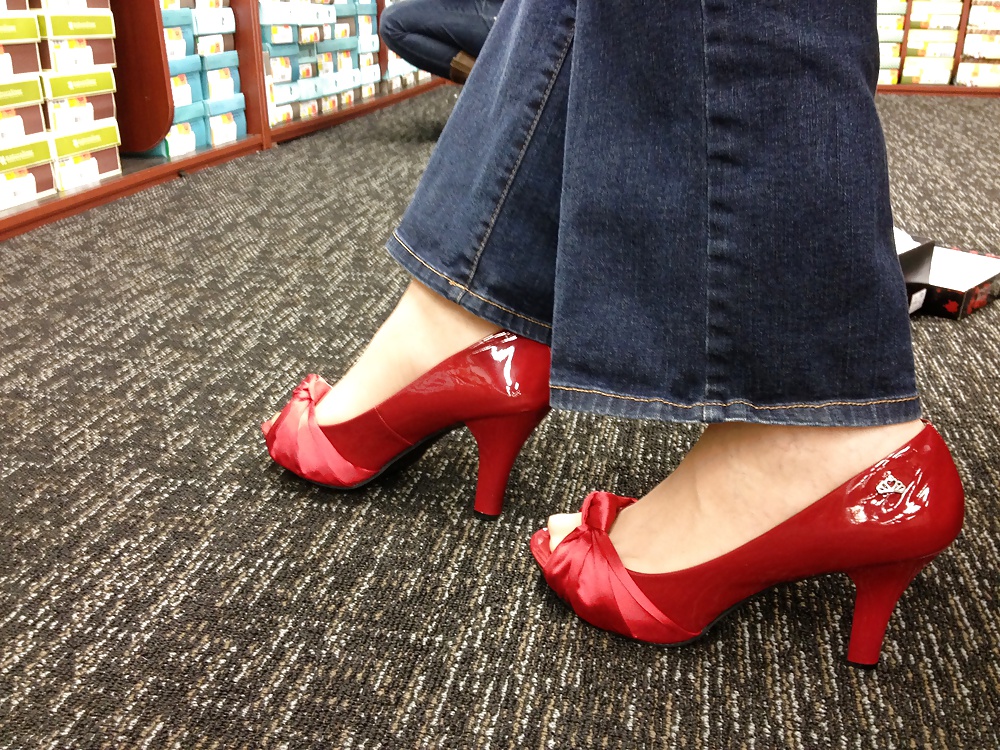 Stocking feet trying on red heels in shoe store #25674017