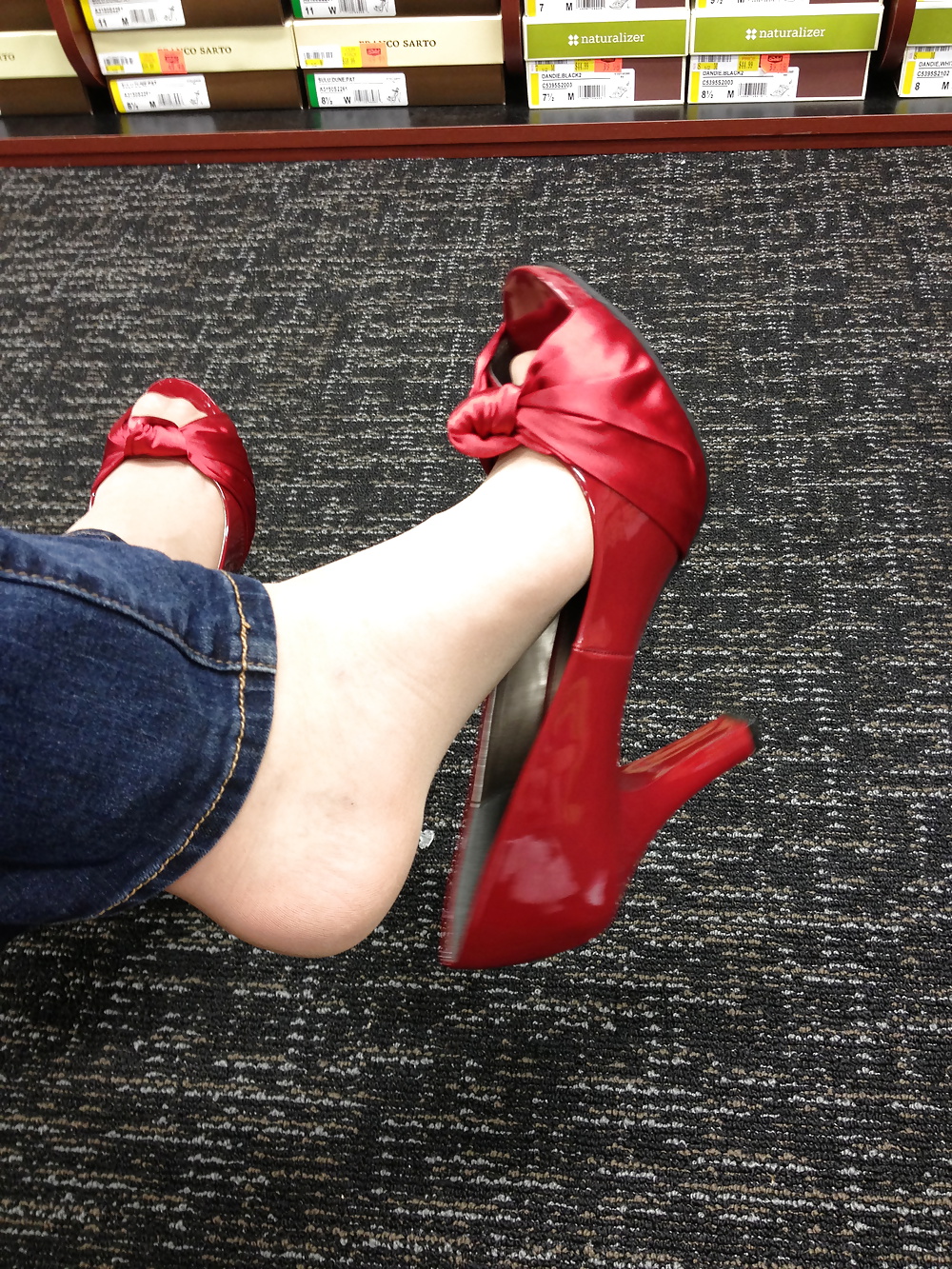 Stocking feet trying on red heels in shoe store #25674090