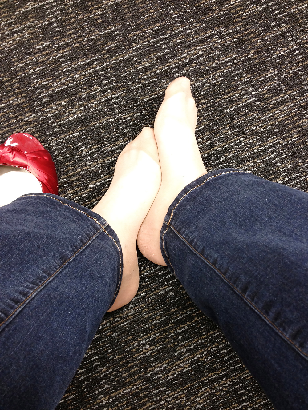 Stocking feet trying on red heels in shoe store #25674128