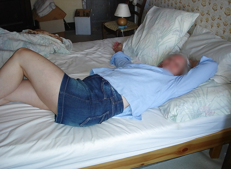 ミニスカートでベッドに横たわる主婦
 #26545991