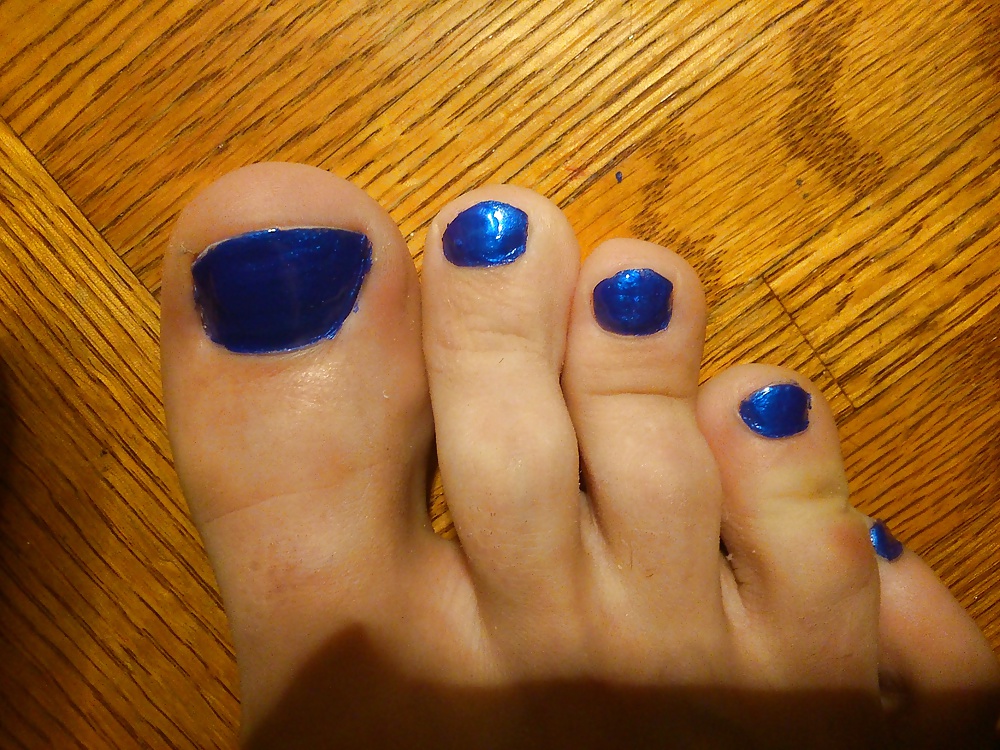 Feet And Toes In Blue Nail Polish And Leather High Heels.