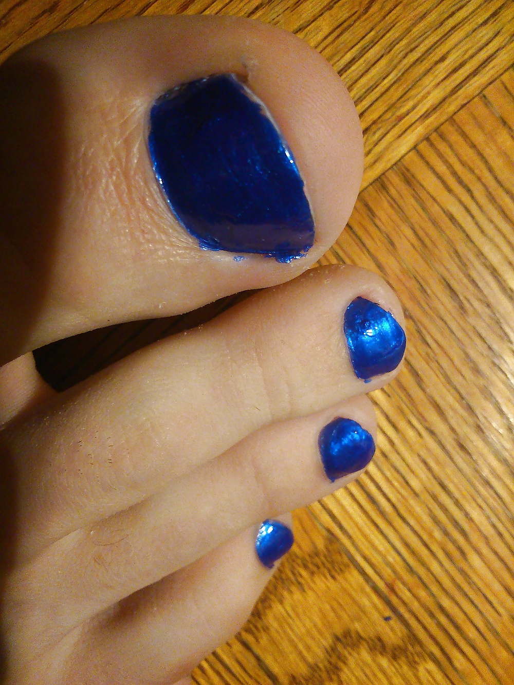 Pies y dedos de los pies en esmalte de uñas azul y tacones de cuero.
 #30148012