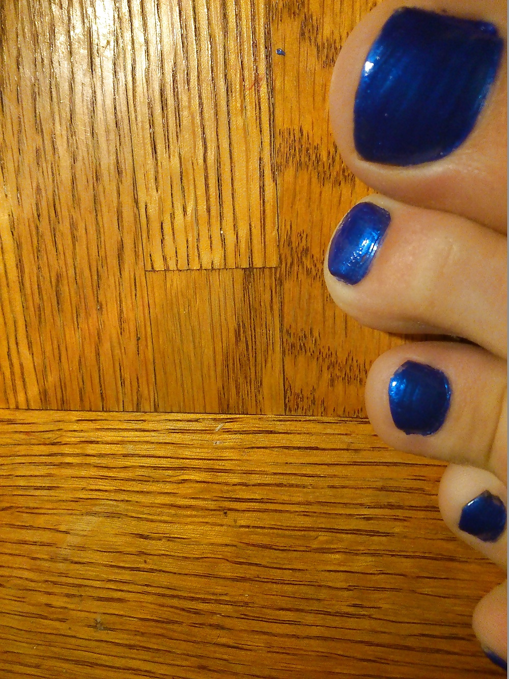 Pies y dedos de los pies en esmalte de uñas azul y tacones de cuero.
 #30148021