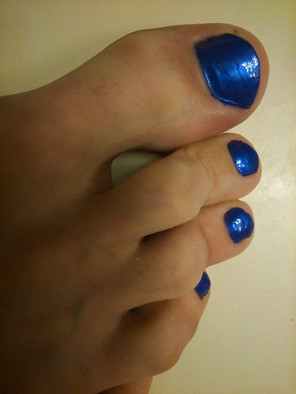 Piedi e dita dei piedi con smalto blu e tacchi alti in pelle.
 #30148031