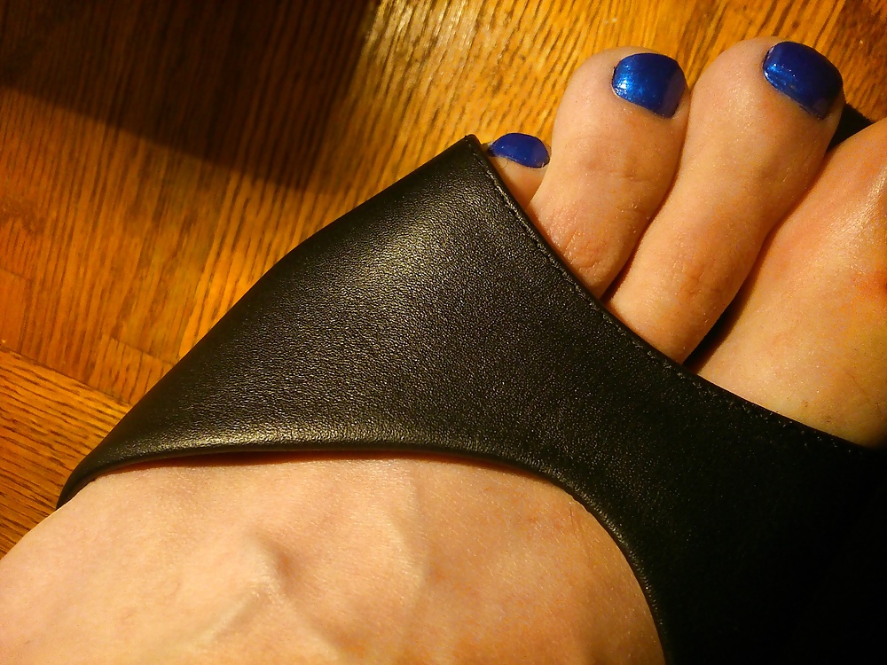 Pies y dedos de los pies en esmalte de uñas azul y tacones de cuero.
 #30148037