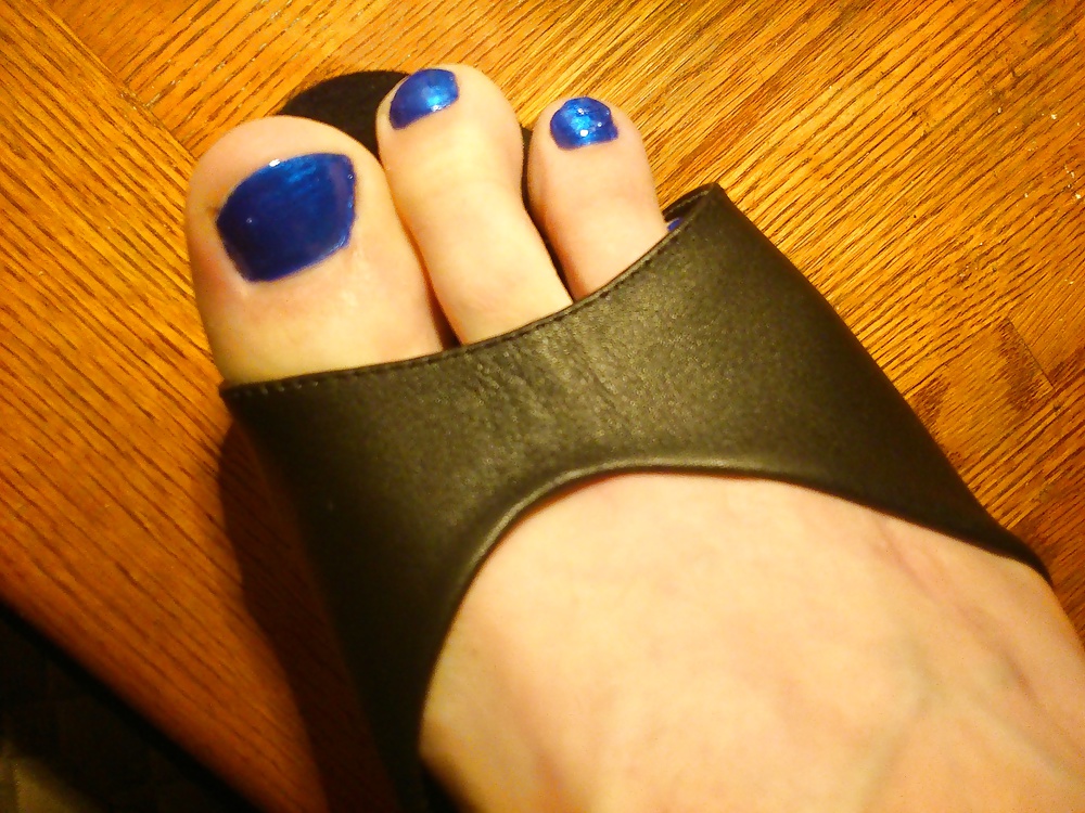 Pies y dedos de los pies en esmalte de uñas azul y tacones de cuero.
 #30148041