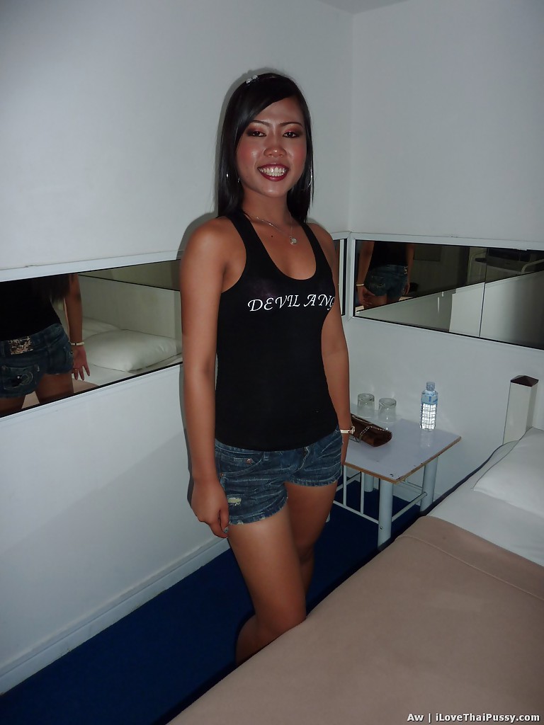 Seducente ragazza asiatica con gambe sottili che posa in pantaloncini di jeans e top nero
 #52204581