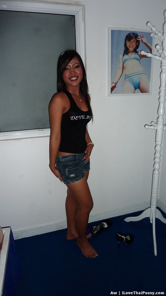 Seducente ragazza asiatica con gambe sottili che posa in pantaloncini di jeans e top nero
 #52204626