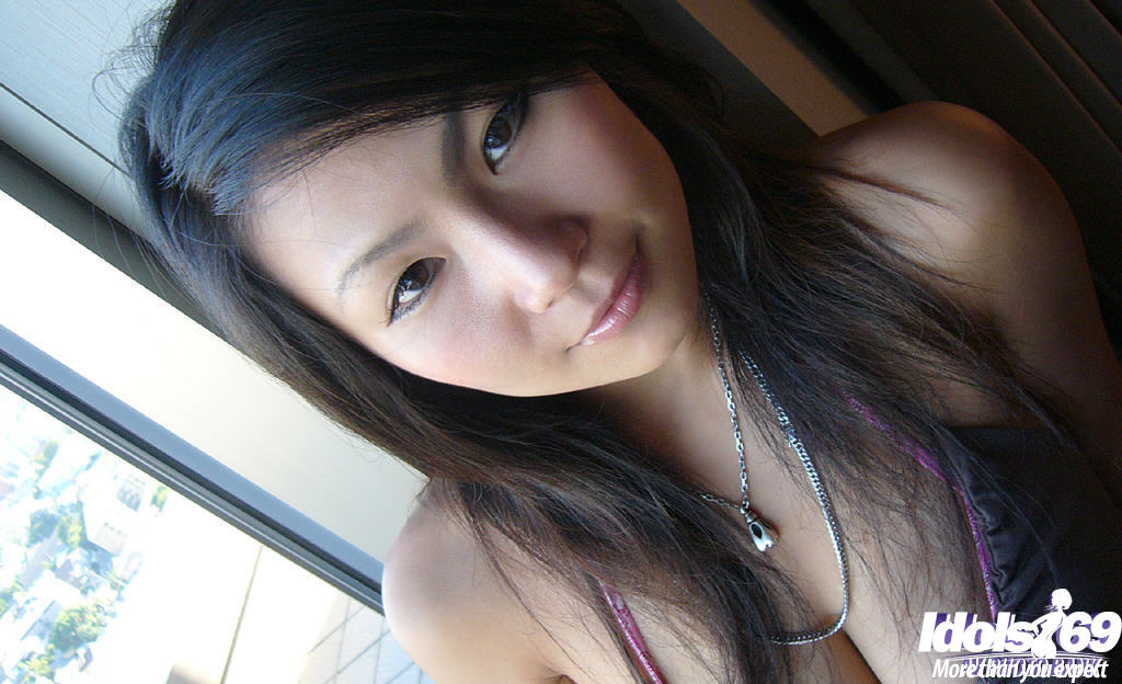 Una asiática sonriente mostrando su pecho tentador con un pezón dulce
 #51188400