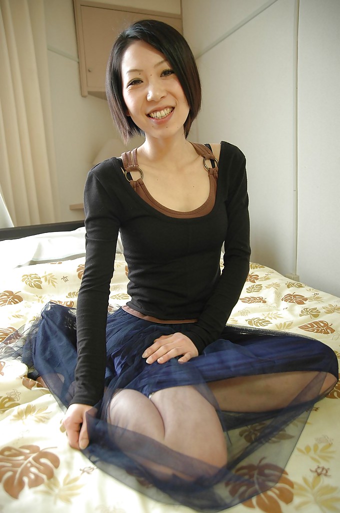 Une asiatique souriante se déshabille et expose ses tétons et sa fente en gros plan.
 #51200669