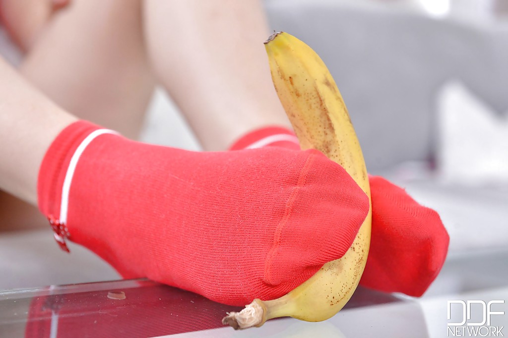Ariana Brown aplastando un plátano con los pies desnudos después de quitarse los calcetines
 #51982425