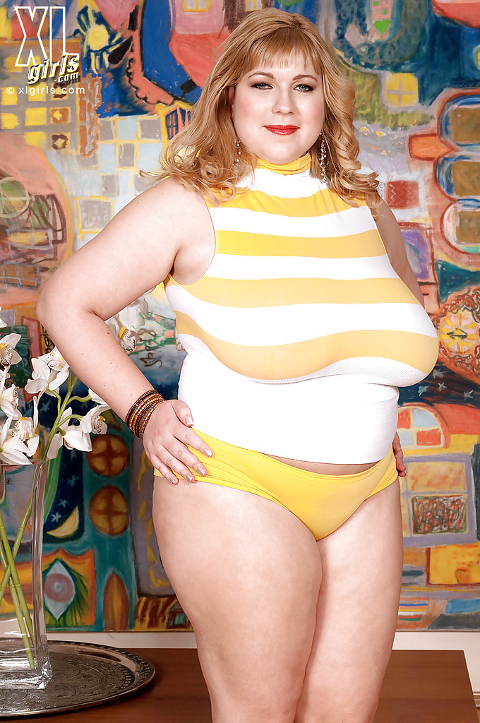 Une blonde aux gros seins et aux grosses fesses, Angellyne Hart, se déshabille jusqu'à la culotte.
 #52096561