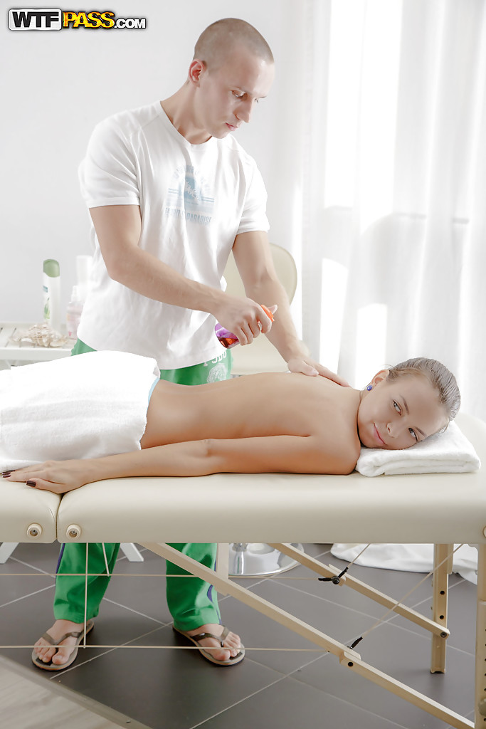 Massaggiatore caldo sta facendo un massaggio rilassante ad una bellezza oliata
 #51307477