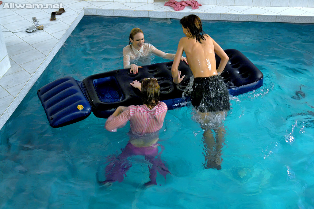 Fetichistas completamente vestidas divirtiéndose en la piscina
 #52626334