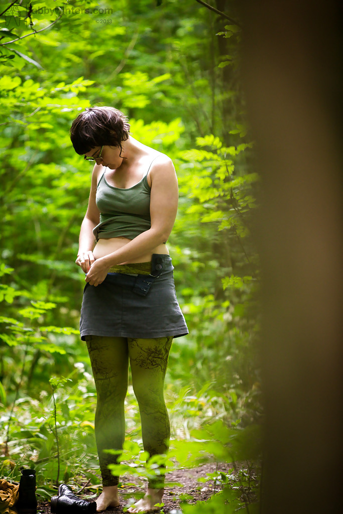 Un voyeur prend des photos d'une brune nue avec des lunettes qui s'habille dans les bois.
 #52333341