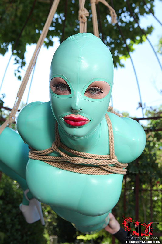 BDSM fetish model Latex Lucy suspended by ropes in latex outfit outdoors #50781230