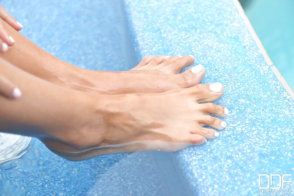 Alexa Tomas, une jeune femme brune aux jambes longues, s'amuse pieds nus au bord d'une piscine.
 #51323671