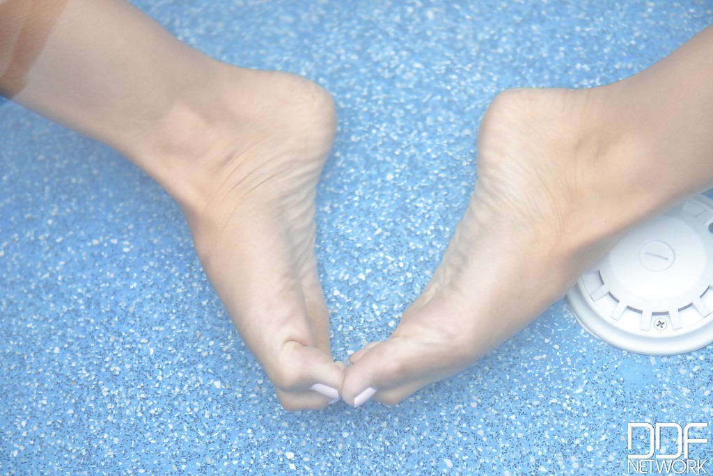 Alexa Tomas, une jeune femme brune aux jambes longues, s'amuse pieds nus au bord d'une piscine.
 #51323681