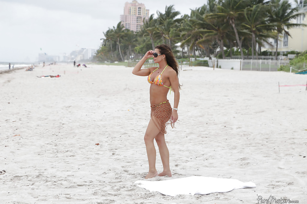 Nina Dolci, femme mûre, libère ses seins fermes de son bikini sur la plage.
 #50169332