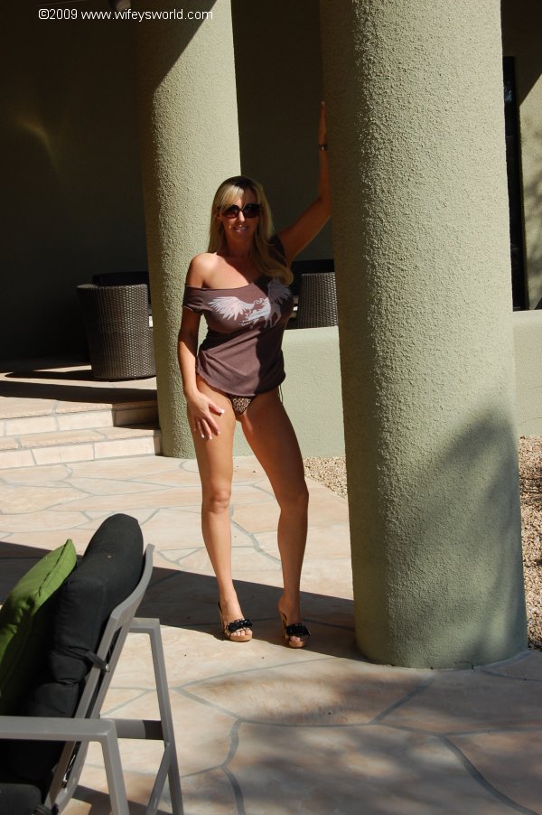 Una esposa tetona y follable se desnuda y posa junto a la piscina
 #55453677