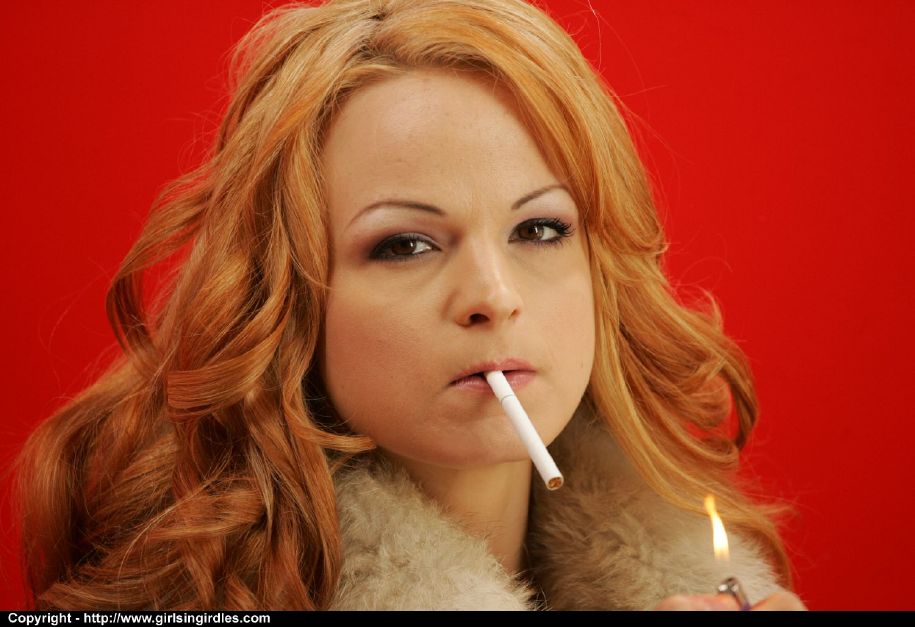 Una pelirroja fumadora en medias mostrando sus tetas y su coño
 #52016021