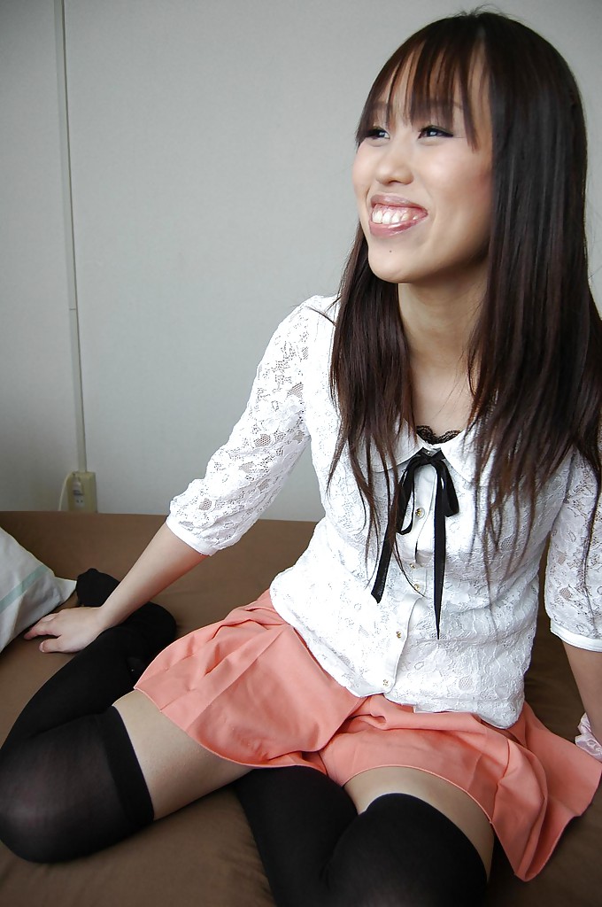 Una chica asiática sonriente se desnuda y expone su coño peludo en un primer plano
 #51413086