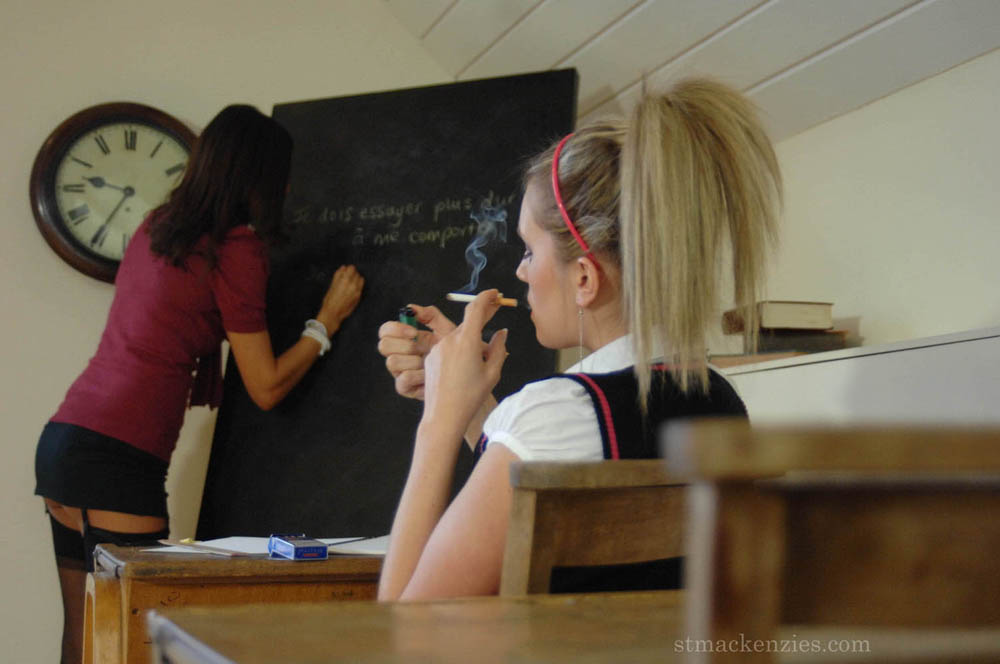 Des écolières chaudes en bas se mettent torse nu et fument dans la classe.
 #51998408