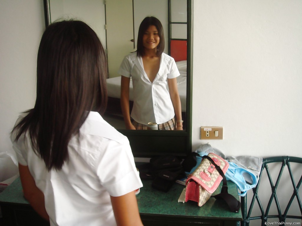 Une jeune fille habillée, apple, enlève sa culotte en se regardant dans le miroir.
 #52327475
