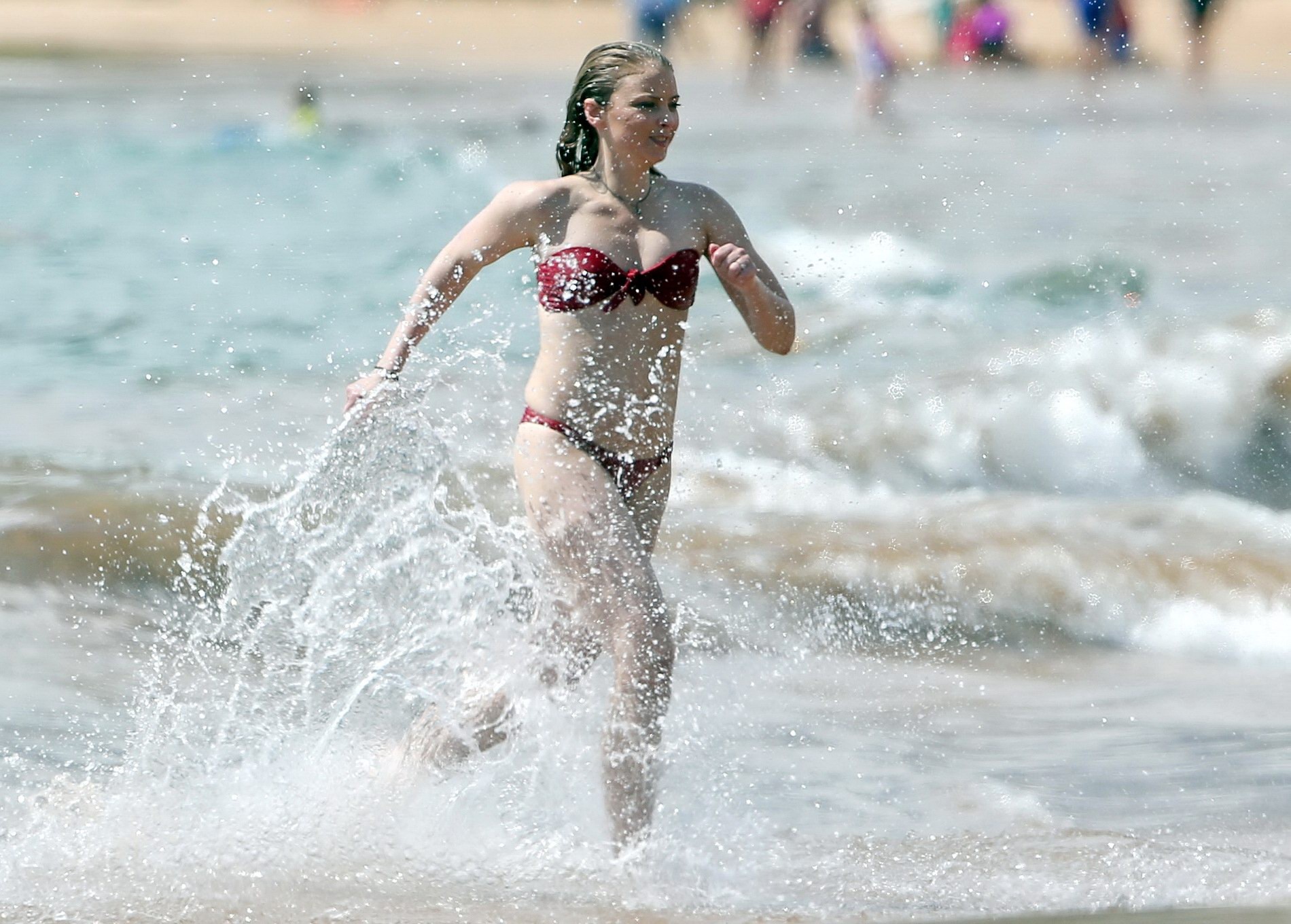 Elisabeth harnois con un bikini rojo sin tirantes en una playa
 #75162878